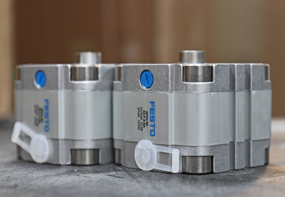 up close view of two festo cylinders on steel surface
